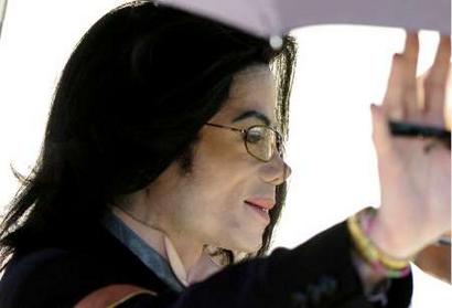 U.S. pop star Michael Jackson gestures to his fans as he leaves the Santa Barbara County Superior Courthouse, after his child molestation trial in Santa Maria, California April 8, 2005. Jackson is charged in the current case with molesting a 13-year-old boy at his Neverland Valley Ranch, plying the youth with alcohol in order to abuse him and conspiring to commit false imprisonment, child abduction and extortion. REUTERS/Phil Klein 