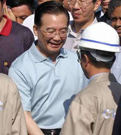 Chinese Premier Wen Jiabao greets a Chinese worker during an inauguration ceremony for post-tsunami reconstruction in the fishing town of Panadura, 20 miles (35 km) south of Colombo, Sri Lanka April 9, 2005. Wen arrived in Sri Lanka on Friday on a two-day leg of a South Asian tour, where he will sign a clutch of bilateral agreements and visit a fishing harbour hammered by last December's tsunami. [Reuters]