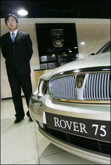 A salesman stands next to a Rover 75 car in a Beijing showroom. The British government sought a last-minute rescue for car maker MG Rover, with or without a proposed Chinese partner, having bought time with a loan to pay this week's wages as an election loomed.(AFP