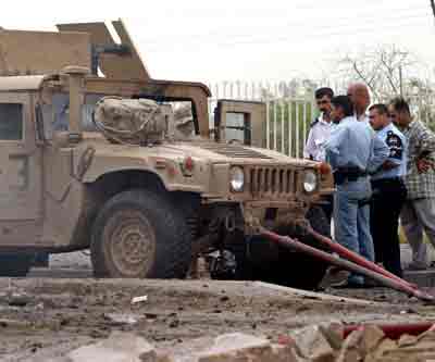 Iraqi police view a damaged U.S. Army Humvee following a roadside bomb attack in Baghdad April 15, 2005. [Reuters]