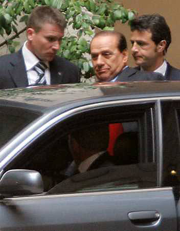 Italy Prime Minister Silvio Berlusconi (C) leaves his residence on his way to meet President Carlo Azeglio Ciampi in Rome April 18, 2005. Italy's government was thrown back into crisis on Monday when Berlusconi denied he had agreed a major reshuffle that would appease rebel ministers and avoid a coalition collapse. REUTERS/Alessia Pierdomenico