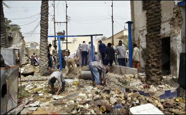 Iraqis inspect the site where a car bomb exploded outside a crowded Shiite mosque in Baghdad. A car bomb killed at least nine people outside a crowded Shiite mosque during Friday prayers just hours after Iraqi insurgents released a video purporting to show the brutal execution of the survivor of a downed helicopter.(AFP