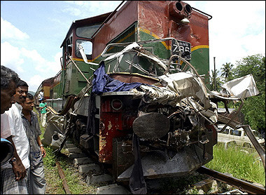 Sri Lankan pedestrians look at the damaged front of a passenger train which collided with a bus near the town of Polgahawela, some 80 kilometres (50 miles) northeast of Colombo.(AFP