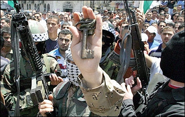 Palestinian gunmen march with an old key during a rally in the West Bank city of Ramallah to mark the Nakba day, 57 years on from the 'catastrophe' of Israel's creation. Palestinians marked the blackest day in their history with warnings that there would be no Middle East peace until they are handed independence and the plight of their refugees is solved.(AFP