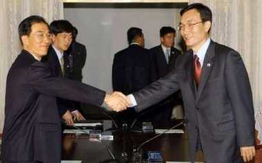South Korean Vice Unification Minister Rhee Bong-jo (R) shakes hands with North Korea's Kim Man-gil on the second day of talks in the North Korean city of Kaesong May 17, 2005. South Korea will press North Korea to return to six-country nuclear talks for the second day on Tuesday when rare high-level bilateral talks resume in the North's city of Kaesong, Seoul's top delegate said.