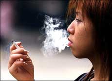 A woman smokes her cigarette on a street in Hong Kong. Too much drinking and smoking, and too little exercise are behind nearly half of all high-fatality disease cases in China, state media said.(AFP