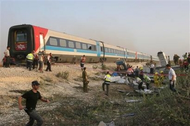 Israeli rescue workers work at the site of a train crash near the village of Revadim, about 40 kilometers south of Tel Aviv, Tuesday June 21, 2005. 