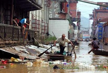 Chinese residents navigate a flooded street in the outskirts of the southern Chinese city of Wuzhou June 24, 2005.