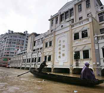 Chinese men use a boat to move in a flooded street in Wuzhou city, southwest China's Guangxi Zhuang Autonomous Region, June 24, 2005. 