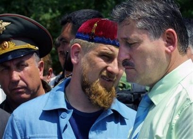 Chechen President Alu Alkhanov, right, and the head of the Chechen presidential security service, first deputy Chechen Prime Minister Ramzan Kadyrov, center, visit a makeshift tent camp settled by the village of Borozdinovskaya residents in an open field near the town of Kizlyar, Dagestan, southern Russia, Sunday, June 26, 2005. 