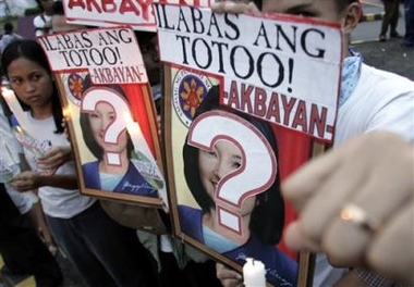 Filipino protesters hold slogans with pictures of Philippine President Gloria Macapagal Arroyo as they call for her ouster in Manila Monday June 27, 2005.