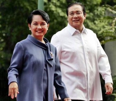 Philippine President Gloria Macapagal Arroyo and first gentleman Jose Miguel Arroyo smile as they are greeted by school children while about to welcome visiting Indonesian President Susilo Bambang Yudhoyono (unseen) at Malacanang Palace in Manila, in this June 21, 2005. file photo. 