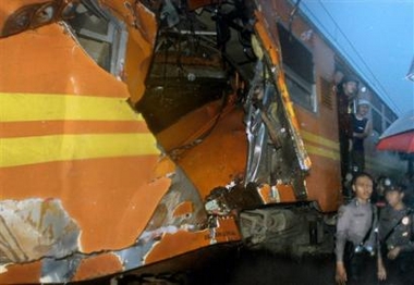 Indonesian police officers stand guard near damaged carriages after a train collision in Jakarta, Indonesia, Thursday, June 30, 2005.