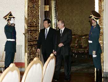 Chinese President Hu Jintao (2nd L) and Russian President Vladimir Putin (2nd R) walk together for a talk held at the Kremlin July 1. (Xinhua)