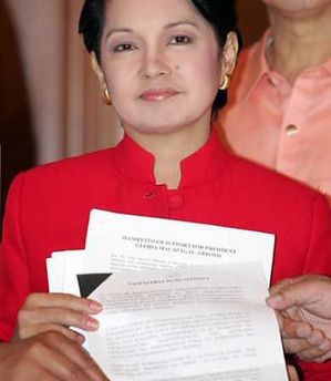 Philippine President Gloria Macapagal Arroyo holds a manifesto of support during a meeting with metro-Manila mayors, pledging their support to the president, at the presidential palace in Manila July 8, 2005. 