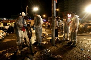 Police investigators inspect the site of a suicide bomb attack in the Israeli coastal town of Natanya Tuesday July 12, 2005.