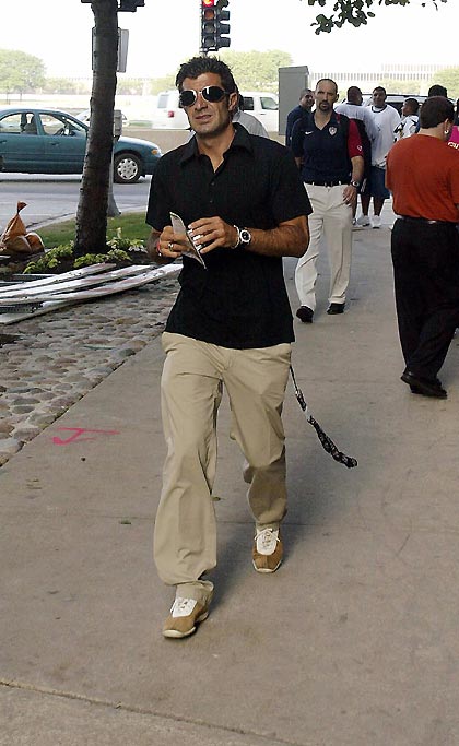 Real Madrid midfielder Luis Figo (L) walks down a street outside the hotel he is staying in, shortly after arriving in Chicago July 14, 2005 for the team's friendly match against Chivas Guadalajara. Figo was expected to drop out of the team's tour in order to sign for either Inter Milan or Liverpool but Real are reported to be holding out for an improved offer for the 32-year-old who still has a year to run on his contract.