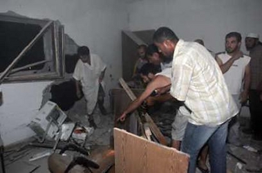 Palestinian men check the damage after Israeli helicopters fired missiles in Gaza city July 15, 2005. Israeli helicopters fired missiles in three separate air raids in the Gaza Strip early on July 15, witnesses said. [Reuters]