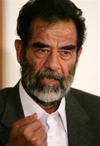 In this image cleared by the U.S. military, former Iraqi President Saddam Hussein appears in a courtroom at Camp Victory, one of his former palaces on the outskirts of Baghdad, on July 1, 2004. The first criminal case has been filed against Saddam Hussein, stemming from a 1982 massacre of dozens of Shiite villagers in retaliation for a failed assassination attempt against the former leader, the head of an Iraqi tribunal said Sunday. (AP 