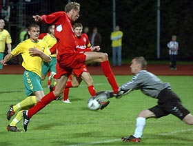 Liverpool's Peter Crouch (C, red) fights for the ball with FBK Kaunas goalkeeper Eduardas Rursris (R) during their Champions League soccer match in Kaunas, Lithuania, July 26, 2005.