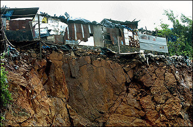 Houses stand on the edge of a landslide in the Saki Naka suburb of Mumbai. Floods, landslides and building collapses caused by India's heaviest-ever recorded rainfall have killed at least 786 people.(AFP