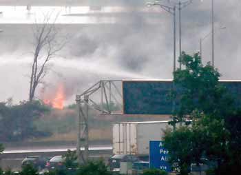 Emergency workers spray foam on an Air France Airbus as it burns just off the runway at Toronto's Pearson International Airport August 2, 2005.