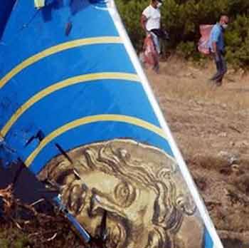 The tail of a Cypriot airliner is seen as investigators carry plastic bags at the crash site where the aircraft slammed into a hill, in the coastal town of Grammatiko, Greece on Monday, Aug. 15, 2005. 