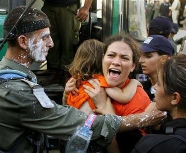 A Jewish settler screams at Israeli troops while carrying her child to an evacuation bus in the Jewish settlement of Kfar Darom, in the Gush Katif settlements bloc, in the southern Gaza Strip, August 18, 2005.