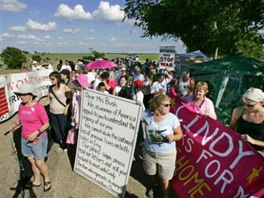 Dozens of women march with a giant letter addressed to U.S. first lady Laura Bush along a road towards the ranch of vacationing U.S. President George W. Bush in Crawford, Texas, August 18, 2005. Dozens of letters, addressed to first lady Bush appealing for her compassion to influence President Bush, were handed to White House representative Bill Burck after the women marched to a police checkpoint near the ranch. [Reuters]