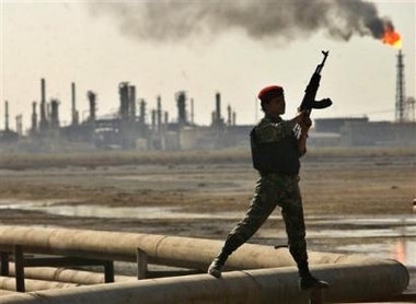 An Iraqi guard provides security at the Al-Shiaaba oil refinery and the pipeline near the southern Iraqi city of Basra, Sunday, Aug. 21, 2005. 