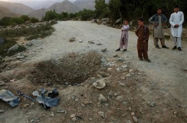 Afghan boys stand near a blast site in the Paghman district on the outskirts of Kabul, Afghanistan on Sunday Aug 21, 2005. Two U.S. Embassy staff were wounded in a roadside bomb in the capital as four 4 U.S. soldiers were killed in another bomb attack in Zabul, southeast Afghanistan. (AP