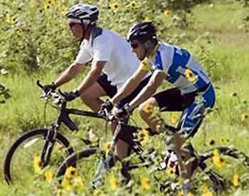 President Bush and 2005 Tour de France winner, Lance Armstrong, right, take a ride together through a field of sunflowers on the president's ranch in Crawford, Texas, Saturday, Aug. 20, 2005. [AP] 