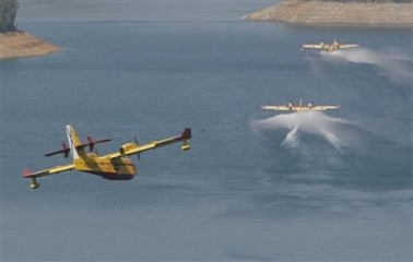 Italian, French and Portuguese Civil Protection Canadair aeroplanes line up to refill at Castelo de Bode dam to drop water over the fire approaching Aldeia de Mato village, 160km(100 miles) north of Lisbon in central Portugal. (AP