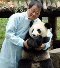 Hong Wendong, leader of 17 experts from Taiwan, poses with a giant panda at the China Giant Panda Protection and Research Centre in Wolong August 27, 2005. [newsphoto]