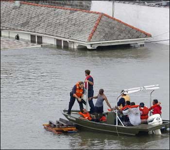 U.S. Coast Guard helicopters plucked survivors from rooftops and firefighters went house-to-house in boats in desperate rescue operations in eastern New Orleans for hundreds of people trapped by floodwaters from Hurricane Katrina. [AFP]