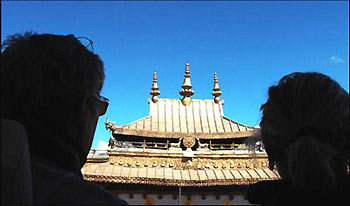 Two European tourists view the golden top of the Johkang Temple in Lhasa, capital of southwest China's Tibet Autonomous Region, August 30, 2005. [People's Daily]