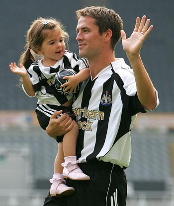 England striker Michael Owen walks across the pitch with his daughter Gemma Rose, wearing a Newcastle United shirt, after his signing by the club at St James' Park in Newcastle August 31, 2005. Owen joins Newcastle United from Spain's Real Madrid. 