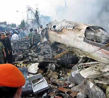 Rescue workers and residents surround the wreckage of an Indonesian Boeing 737-200 operated by Mandala Airlines which crashed just after takeoff near a housing complex in the city of Medan, on Indonesia's Sumatra island September 5, 2005. [Reuters]