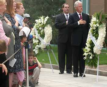 Former U.S. president Bill Clinton (R) and fellow Americans pay their respects as the U.S. flag was raised to half-mast during a service commemorating the September 11, 2001 attacks, at the U.S. embassy in Beijing, September 11, 2005. [Reuters]