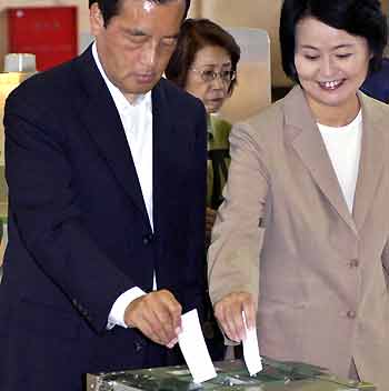 Japan's main opposition Democratic Party leader Katsuya Okada (L) casts his ballot with his wife Tatsuko (R) at a polling station for Japan's general election in Yokkaichi, central Japan, September 11, 2005. 