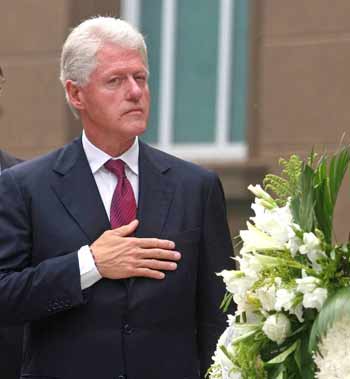 Dressed in a dark suit, former U.S. president Bill Clinton pays his respects as the US flag was raised to half-mast during a service commemorating the September 11, 2001 attacks, at the U.S. embassy in Beijing, September 11, 2005. [Reuters]