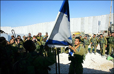 Israeli soldiers from the Golani brigade take part in a flag-lowering ceremony as they prepare to withdraw from the Girit outpost in the southern Gaza Strip. 