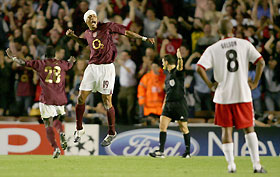 Arsenal's Gilberto (C) celebrates Dennis Bergkamp's (unseen) winning goal with Kolo Toure (L), while Thun's Rodriguez Gelson De Souza (R) looks on during their Champions League Group B soccer match at Highbury in London, September 14, 2005.