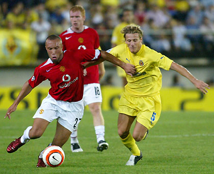 Manchester United's Mikael Silvestre of France (L) and Villarreal's Diego Forlan of Uruguay battle for the ball during their Champions League Group D soccer match at the El Madrigal Stadium in Villarreal September 14, 2005.