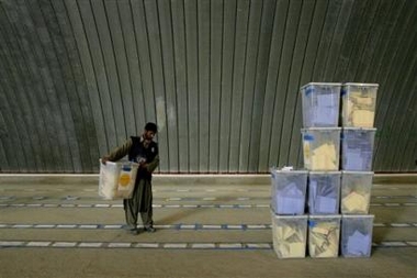 An election worker carries a ballot box at a counting center in Kabul, Afghanistan, Tuesday, Sept. 20, 2005. Afghanistan continues the long process of collecting and counting votes Tuesday, two day after landmark legislative elections. (AP