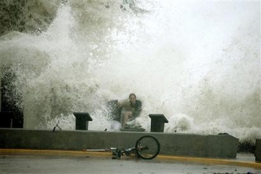 A ocean wave crashes over a sightseer in Key West, Fla. Tuesday, Sept. 20, 2005, as Hurricane Rita brushes past the area. (AP