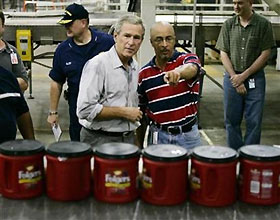 President George W. Bush is shown around at the back-in-operation Folgers Coffee Plant by operations manager Bart Blackstone (R) in New Orleans September 20, 2005. 