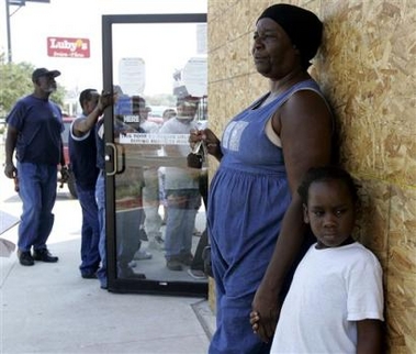 Wilma Skinner holds the hand of her grandson, Dageneral Bellard, 6, right, as they wait outside a check cashing office in Houston, Thursday, Sept. 22, 2005. Skinner said she is concerned because she has no way out of the city, which is preparing for the arrival of Hurricane Rita. [AP]