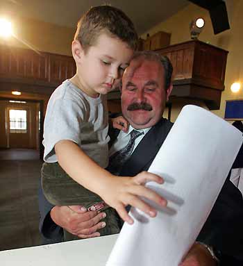 Three-year-old Kuba Domagalek helps his father to cast his ballot at a polling station in the country's general election in the village of Gdow, outside Krakow, southern Poland September 25, 2005. [Reuters]