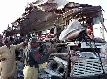 Pakistani officials examine the wreckage of a passenger bus after a road accident near Sehwan, 300 km (188 miles) from Karachi September 25, 2005. At least 39 people were killed and more than 150 injured in two road accidents within hours of each other on the same stretch of highway in Pakistan's southern Sindh province, officials said on Sunday. [Reuters]
